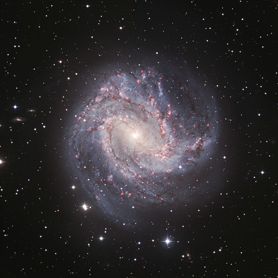 The colored image shows a spiral-shaped, light blue and white galaxy with a brightly shining center. In the background is the black universe.